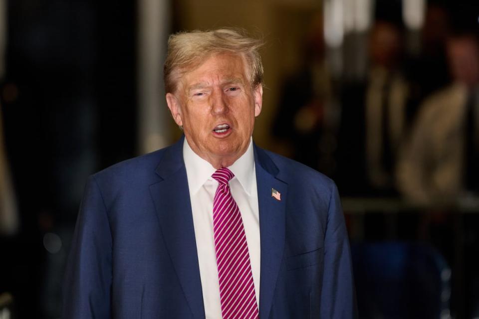 Former President Donald Trump speaks to the media as he enters Manhattan Criminal Court.