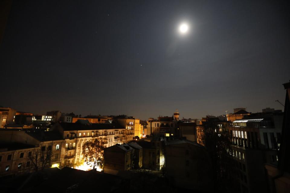 The moon shining over downtown Kyiv at night