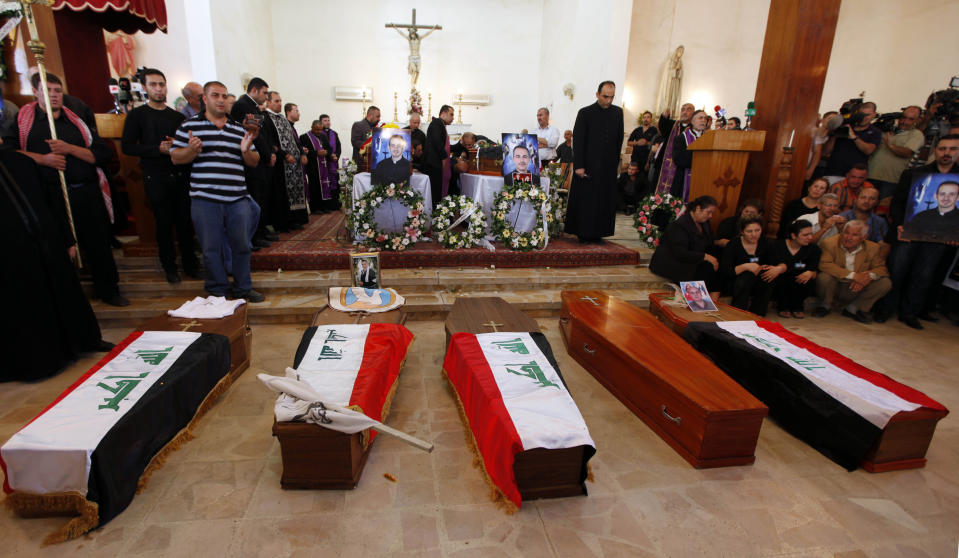 FILE - In this Nov. 2, 2010 file photo, mourners stand near the coffins of two slain priests and their parishioners at a funeral mass in Baghdad, Iraq,. The victims were killed Sunday when gunmen stormed a church during mass and took the entire congregation hostage. Iraq was estimated to have more than 1 million Christians before the 2003 U.S.-led invasion that toppled dictator Saddam Hussein. Now, church officials estimate only few hundred remain within Iraq borders. The rest are scattered across the globe, resettling in far-flung places like Australia, Canada and Sweden as well as neighboring countries. (AP Photo/Hadi Mizban)