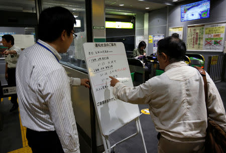 A passenger checks a message board announcing last train services ending earlier due to Typhoon Trami, at East Japan Railway Company's station in Tokyo, Japan, September 30, 2018. REUTERS/Issei Kato