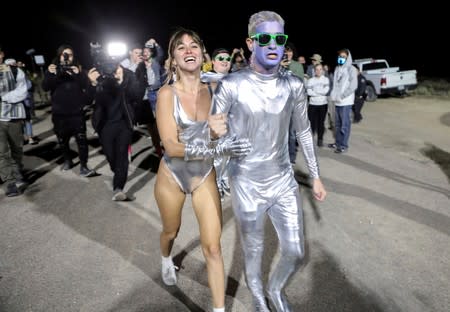 FILE PHOTO: People dressed in costumes chant as they approach a gate to Area 51 in Rachel, Nevada