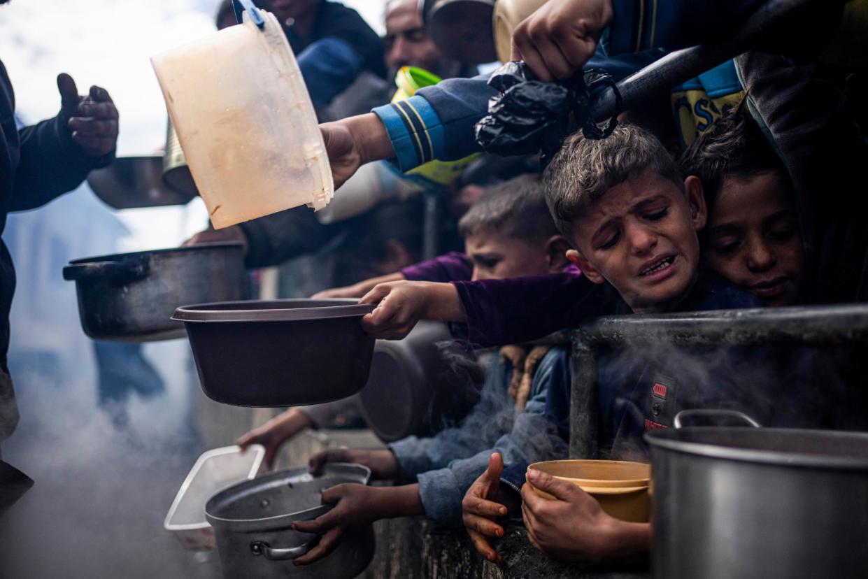 <span>Palestinians line up for a free meal in Rafah, Gaza Strip, on 16 February.</span><span>Photograph: Fatima Shbair/AP</span>