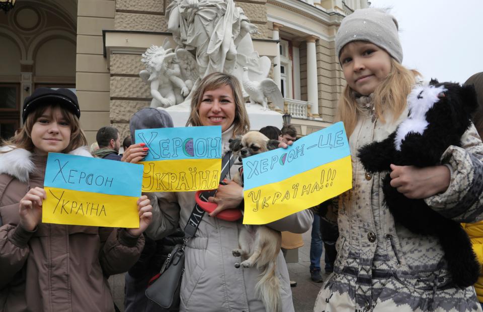 Ukrainians gather downtown to celebrate the recapturing of Kherson city, Ukraine, Odesa, Saturday, Nov. 12, 2022. People across Ukraine awoke from a night of jubilant celebrating after the Kremlin announced its troops had withdrawn to the other side of the Dnieper River from Kherson, the only regional capital captured by Russia's military during the ongoing invasion. Signs on flags reading "Kherson is Ukraine."