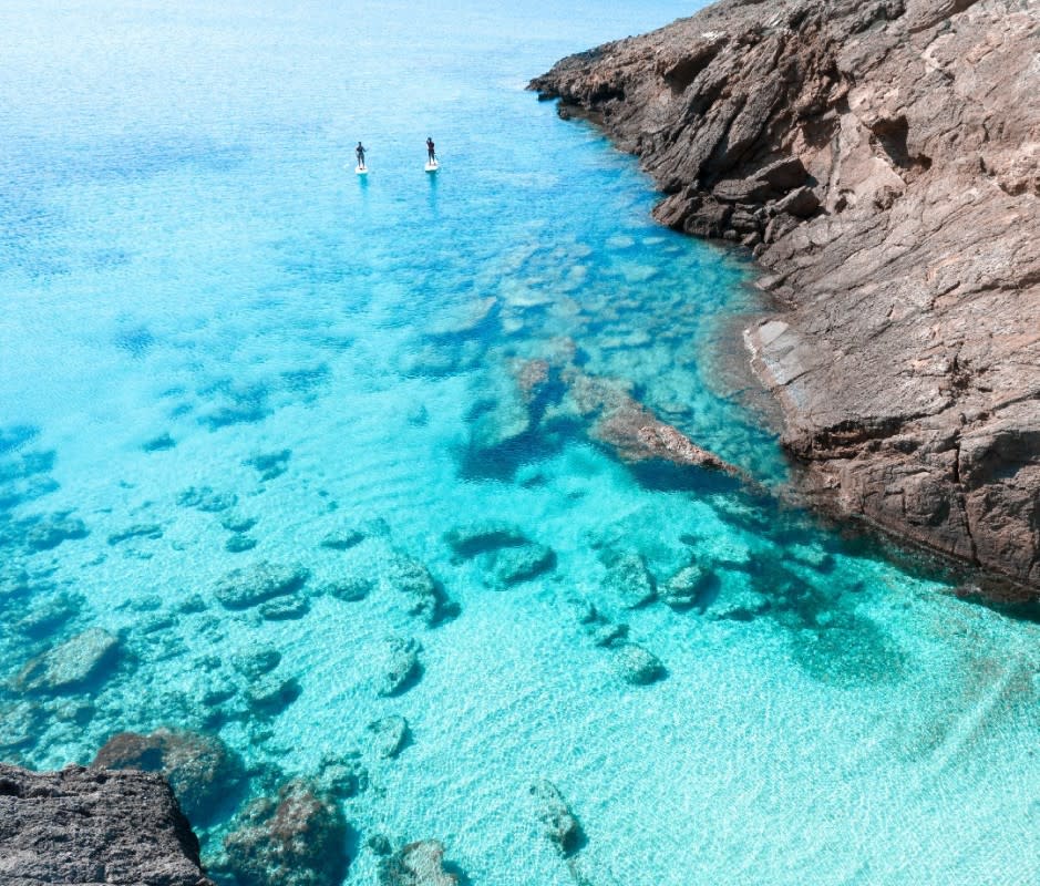 Menorca's clear turquoise waters and hidden coves are a refuge for "slow travelers"—inviting quiet exploration from all sides.<p>Artur Debat/Getty Images</p>