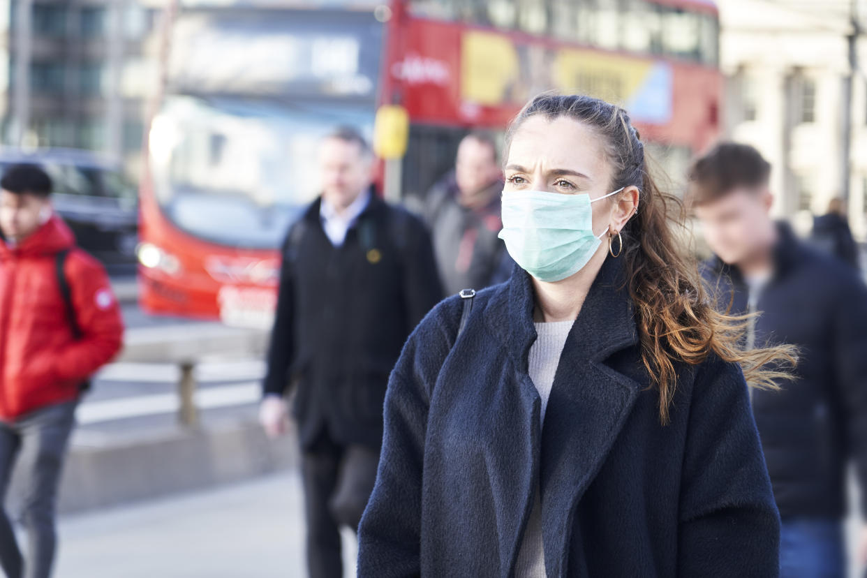 Young woman wearing face mask while walking in the streets of London