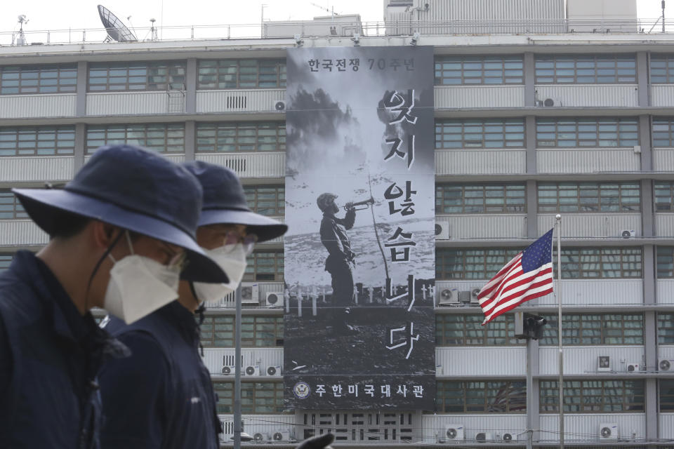 People walk by a banner to commemorate the 70th anniversary of the start of the 1950-53 Korean War at the U.S. Embassy in Seoul, South Korea, Tuesday, June 16, 2020. A large Black Lives Matter banner has been removed from the U.S. Embassy building, three days after it was raised there in solidarity with protesters back home. The sign reads "Don't forget it." (AP Photo/Ahn Young-joon)