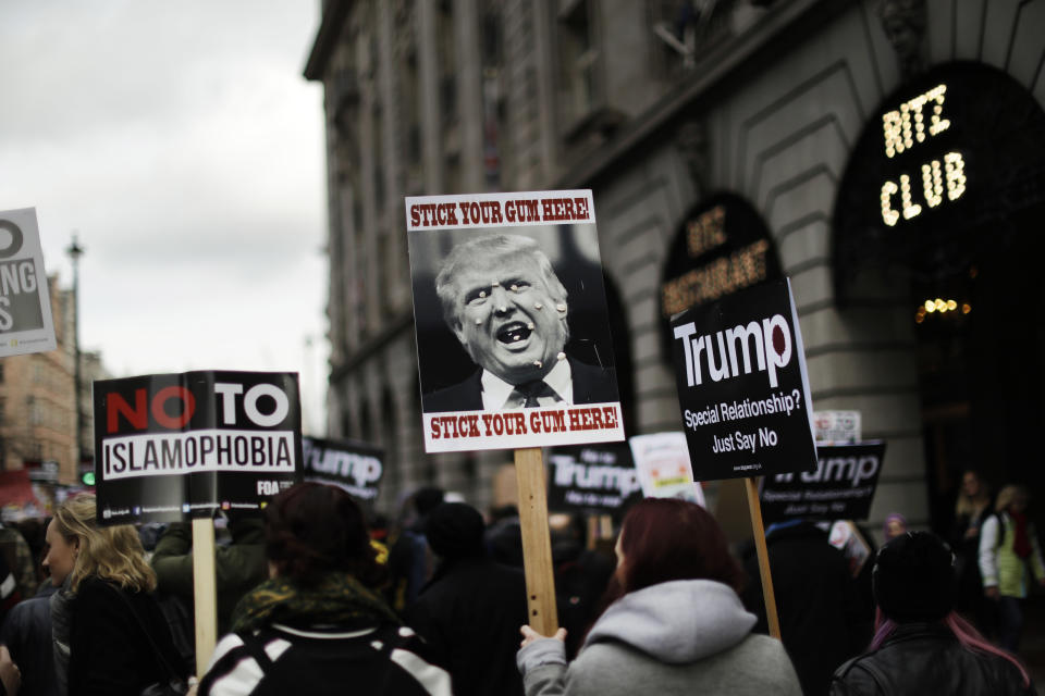 People hold placards as they take part in a protest march in London, against U.S. President Donald Trump's ban on travellers and immigrants from seven predominantly Muslim countries entering the U.S., Saturday, Feb. 4, 2017. Thousands of protesters have marched on Parliament in London to demand that the British government withdraw its invitation to U.S. President Donald Trump. (AP Photo/Matt Dunham)