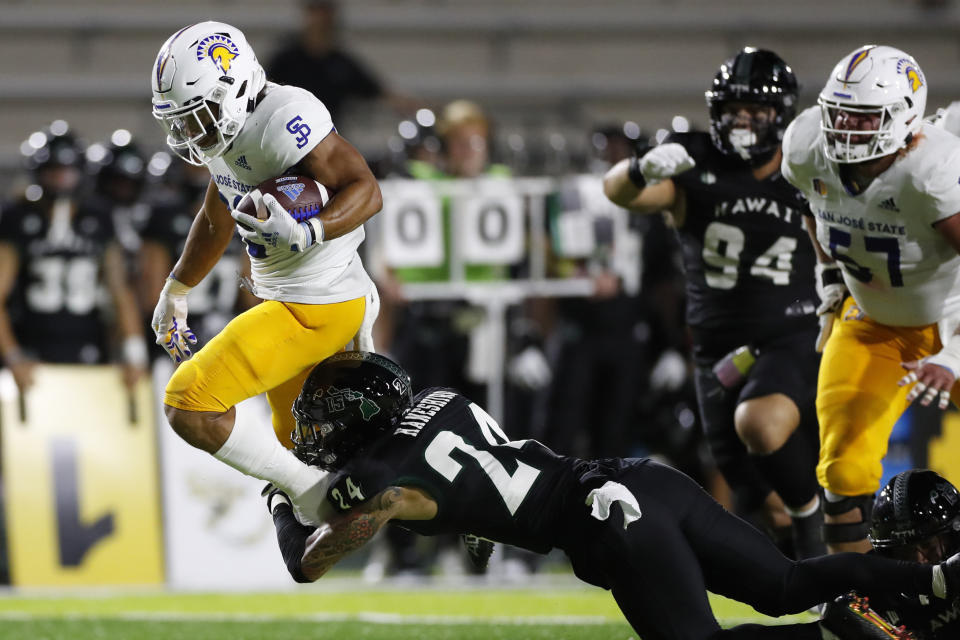 Hawaii defensive back Kai Kaneshiro (24) trips up San Jose State running back Kairee Robinson (32) during the first half of an NCAA college football game, Saturday, Sept. 18, 2021, in Honolulu. (AP Photo/Marco Garcia)