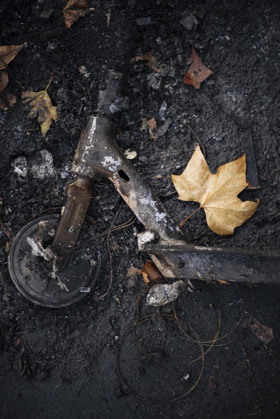 A charred scooter lays on burned ground near by of the Madeleine church in Paris, Sunday, Dec. 2, 2018. A protest against rising taxes and the high cost of living turned into a riot in the French capital, as activists torched cars, smashed windows, looted stores and tagged the Arc de Triomphe with multi-colored graffiti. (AP Photo/Kamil Zihnioglu)