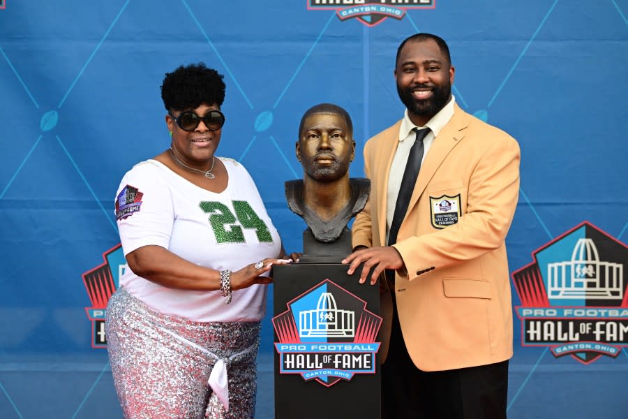 Former NFL player Darrelle Revis, right, and his mother Diana Gilbert pose with his bust during his induction into the Pro Football Hall of Fame in Canton, Ohio, Saturday, Aug. 5, 2023. (AP Photo/David Dermer)