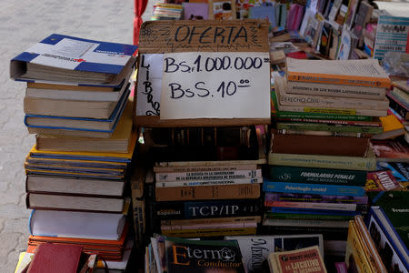 A sign displaying prices of used books in the current Strong bolivar currency as well as the new Sovereign bolivar currency is seen at a stall in Caracas, Venezuela August 17, 2018. REUTERS/Marco Bello