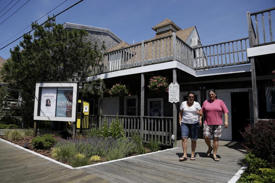 In this June 23, 2013 photo, people leave a Sunday morning church service at the Cherry Grove Community House and Theater on Fire Island in Cherry Grove, N.Y. Residents of Cherry Grove are celebrating the addition of the theater to the National Register of Historic Places. The designation announced in June confirms that the facility opened in 1948 is the oldest continuously operating gay and lesbian theater in the United States. Locals note that 20 years before the Stonewall riots in New York City helped launch the gay rights movement, gays and lesbians were freely expressing themselves in Cherry Grove. (AP Photo/Seth Wenig)