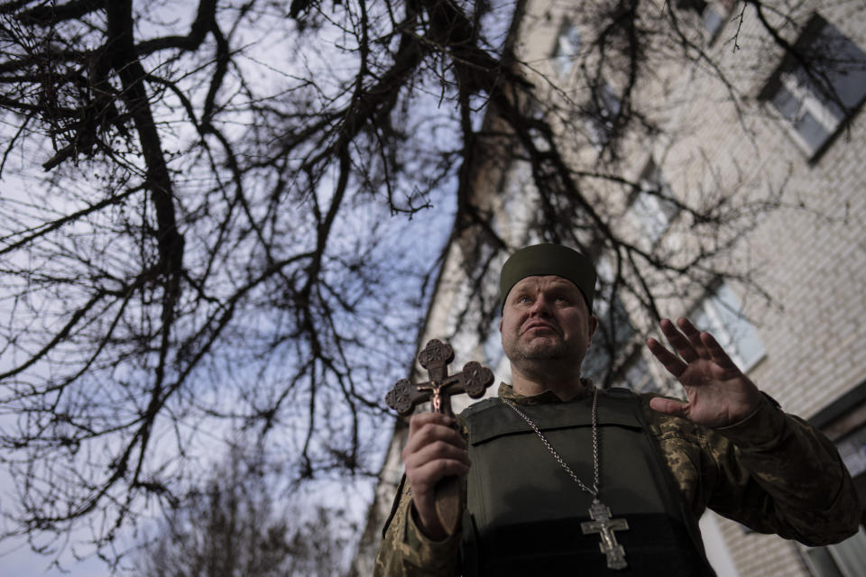 Chaplain Dmitri talks to neighbors in Bucha, in the outskirts of Kyiv, Ukraine, Friday, April 8, 2022. (AP Photo/Rodrigo Abd)