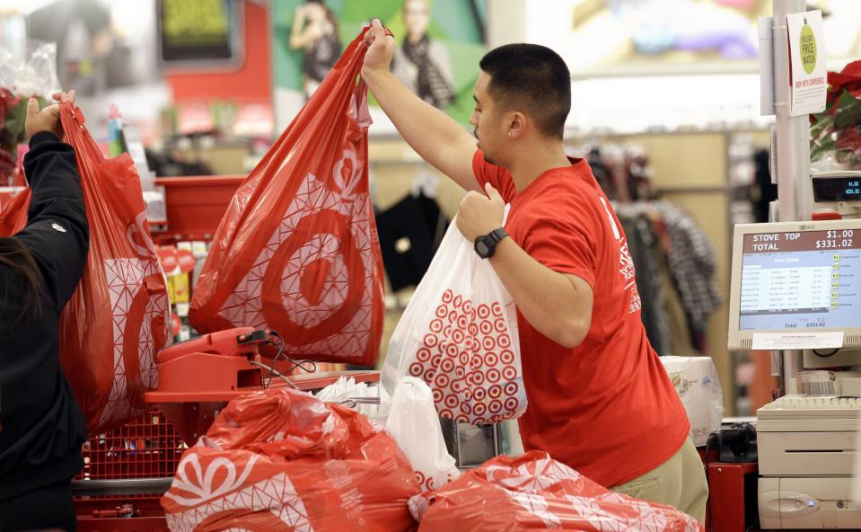 A Target employee hands bags to a customer at the register at a Target store in Colma, Calif., Friday, Nov. 23, 2012. Black Friday, the day when retailers traditionally turn a profit for the year, got a jump start this year as many stores opened just as families were finishing up Thanksgiving dinner. Stores are experimenting with ways to compete with online rivals like Amazon.com that can offer holiday shopping deals at any time and on any day.  (AP Photo/Jeff Chiu)