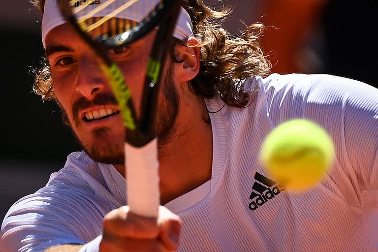 El griego Stefanos Tsitsipas devuelve el balón al serbio Novak Djokovic durante su último partido de tenis masculino el día 15 del torneo de tenis del Abierto de Francia de Roland Garros 2021 en París el 13 de junio de 2021 (Foto de Anne-Christine POUJOULAT / AFP).