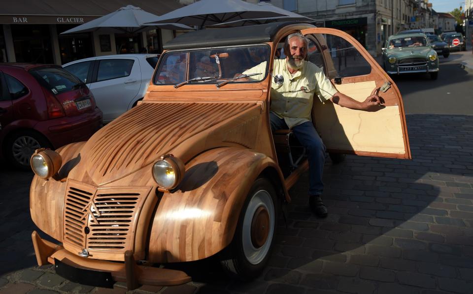 French cabinetmaker Michel Robillard poses in his wooden Citroen   2CV car in the streets of Loches, France, in a September 23, 2017 file photo. / Credit: GUILLAUME SOUVANT/AFP/Getty