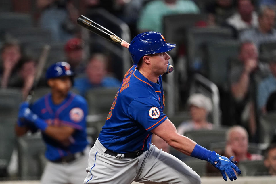 New York Mets' James McCann follows through on an RBI-double in the seventh inning of a baseball game against the Atlanta Braves, Monday, May 17, 2021, in Atlanta. (AP Photo/John Bazemore)