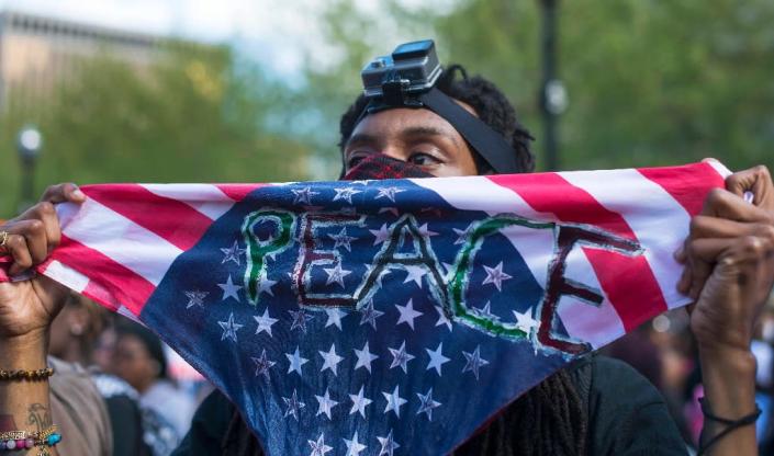 A demonstrator holds up a peace sign during a rally protest in front of City Hall in Baltimore, Maryland, May 2, 2015 (AFP Photo/Jim Watson)