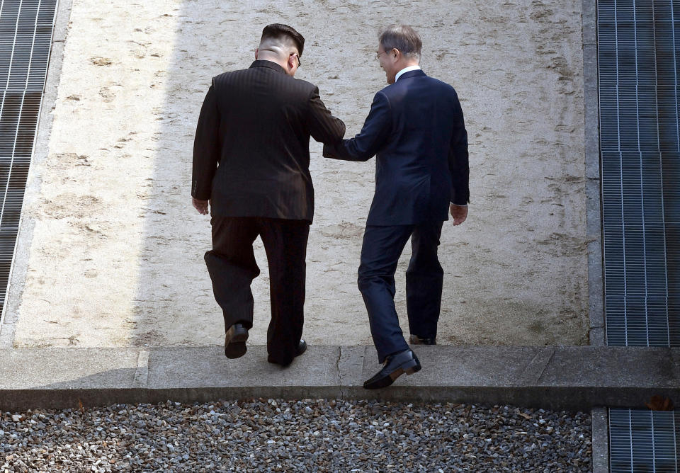 <p>North Korean leader Kim Jong Un, left, and South Korean President Moon Jae-in cross the military demarcation line at the border village of Panmunjom in Demilitarized Zone Friday, April 27, 2018. (Photo: Korea Summit Press Pool via AP) </p>