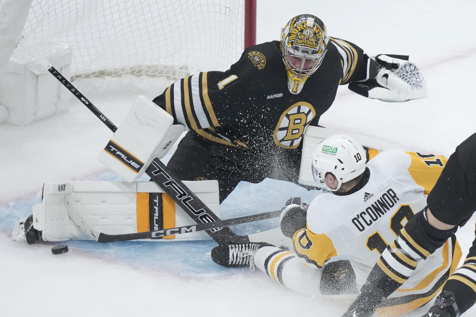 Pittsburgh Penguins left wing Drew O'Connor (10) tries to score as Boston Bruins goaltender Jeremy Swayman (1) deflects the puck in the first period of an NHL hockey game, Thursday, Jan. 4, 2024, in Boston. (AP Photo/Steven Senne)