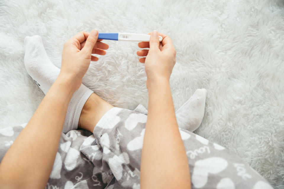 sad woman looking on pregnancy test unexpected