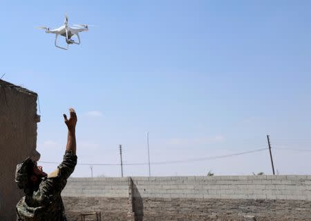 A fighter from SDF flies a drone in western Raqqa province. REUTERS/Rodi Said