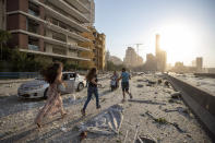 Unas personas corren luego de una explosión en Beirut, Líbano, el martes 4 de agosto de 2020. (AP Foto/Hassan Ammar)