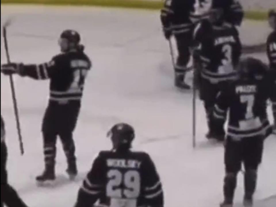 A Dauphin Kings player, left, makes an apparent bow-and-arrow gesture during a weekend game against the Wolverines from Waywayseecappo First Nation. (Twitter - image credit)