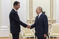 Russian President Vladimir Putin, right, greets Syrian President Bashar Assad during their meeting in the Kremlin in Moscow, Russia, Monday, Sept. 13, 2021. (Mikhail Klimentyev, Sputnik, Kremlin Pool Photo via AP)