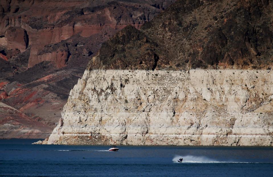 Boaters are dwarfed by a white "bathtub ring" around Lake Mead.