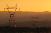 This Aug. 20, 2019, image shows transmission lines leading from the Navajo Generating Station near Page, Ariz. The power plant will close before the year ends. Other coal-fired plants in the region and in the U.S. are on track to shut down or reduce output as utilities turn to natural gas and renewable energy. (AP Photo/Susan Montoya Bryan)