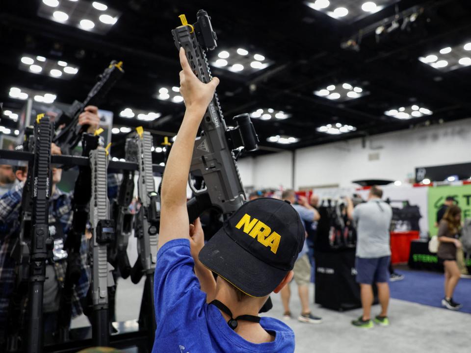 Arie Eckart, 10, from Indiana, holds a gun at the National Rifle Association (NRA) annual convention in Indianapolis, Indiana.