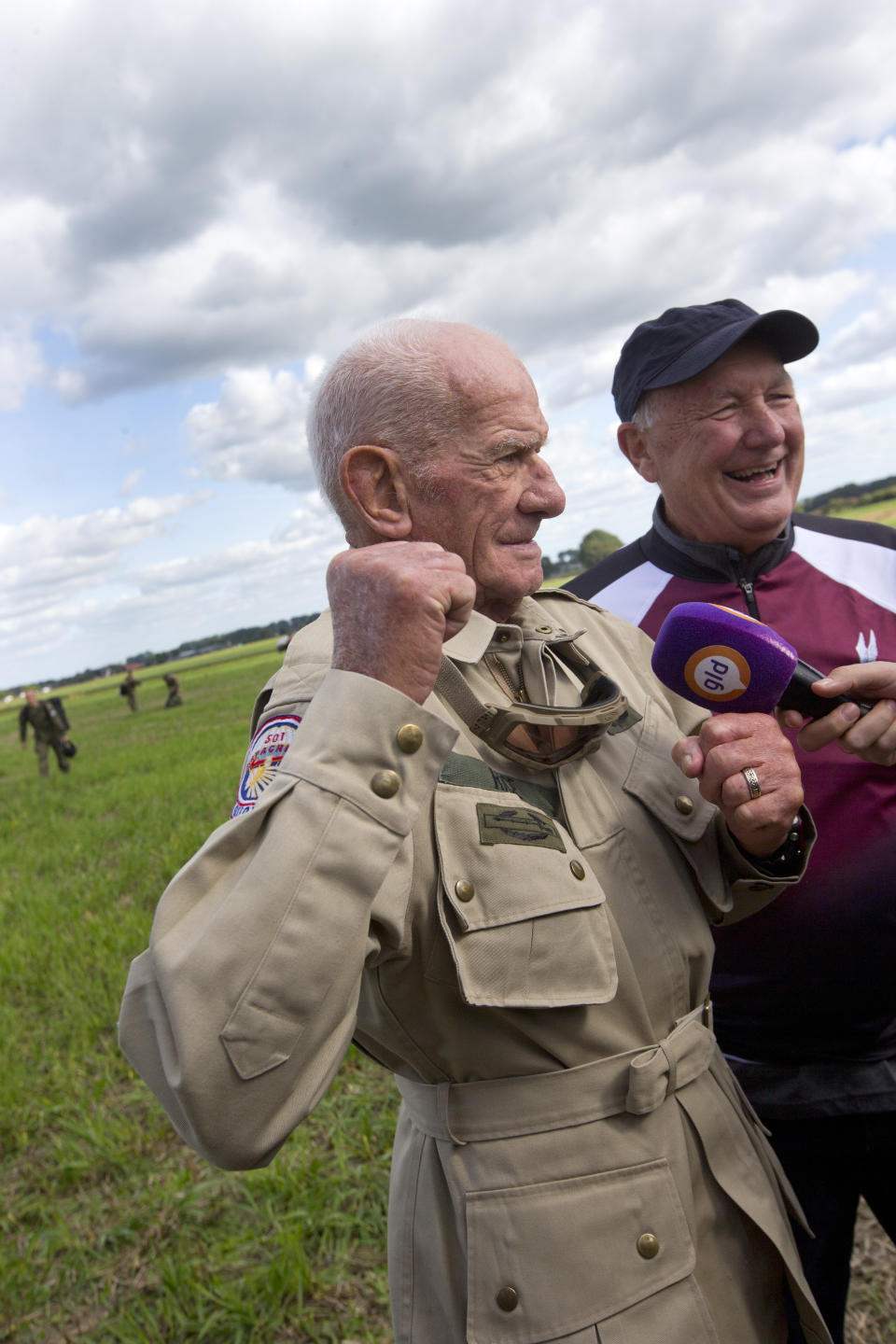 Tom Rice, a 98-year-old American WWII veteran, and U.S. Ambassador Pete Hoekstra, right, talk to journalists after landing with a tandem parachute jump near Groesbeek, Netherlands, Thursday, Sept. 19, 2019, as part of commemorations marking the 75th anniversary of Operation Market Garden. Rice jumped with the U.S. Army's 101st Airborne Division in Normandy, landing safely despite catching himself on the exit and a bullet striking his parachute. (AP Photo/Peter Dejong)