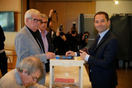 Benoit Hamon (R), French Socialist party 2017 presidential candidate, casts his ballot in the first round of 2017 French presidential election at a polling station in Trappes, near Paris, France, April 23, 2017. REUTERS/Vincent Kessler