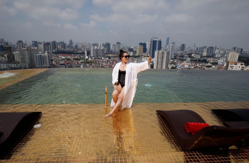 A woman poses for a photo at the gold plated infinity pool of the newly-inaugurated Dolce Hanoi Golden Lake luxury hotel, after the government eased a nationwide lockdown following the global outbreak of the coronavirus disease (COVID-19), in Hanoi