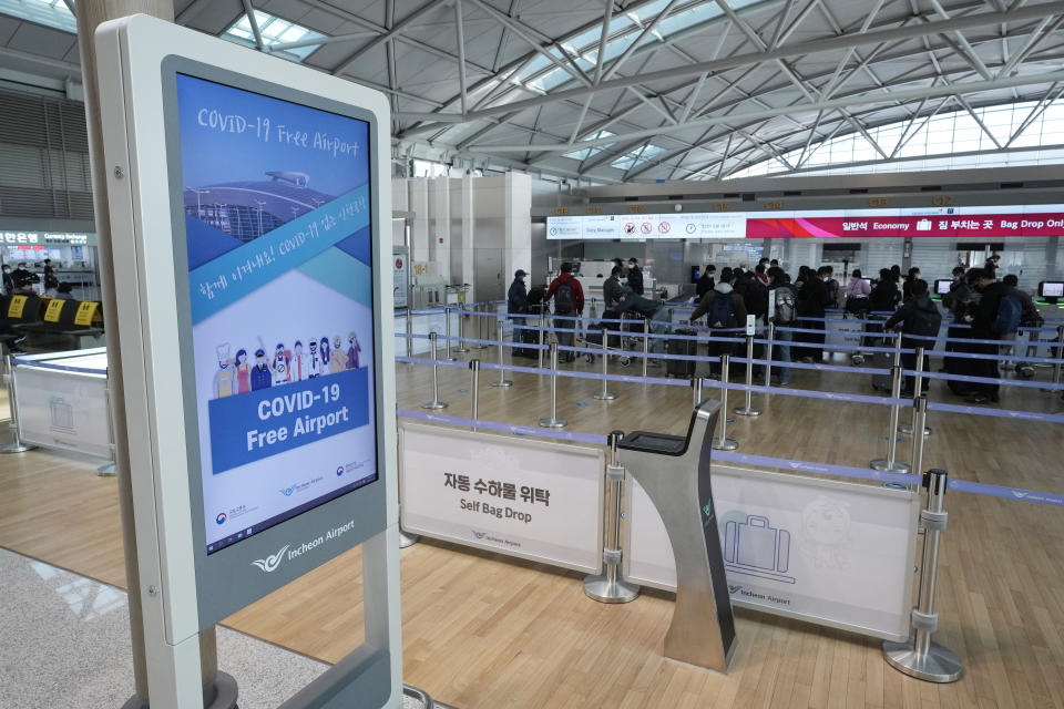 Passengers wait in line to board a plane at the Incheon International Airport In Incheon, South Korea, Wednesday, Dec. 1, 2021. South Korea's daily jump in coronavirus infections exceeded 5,000 for the first time since the start of the pandemic, as a delta-driven surge also pushed hospitalizations and deaths to record highs. (AP Photo/Ahn Young-joon).