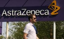 FILE PHOTO: A man walks past a sign at an AstraZeneca site in Macclesfield