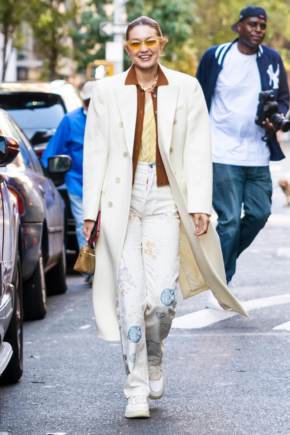 <p>Gigi Hadid sports a long white coat with a stylish pair of yellow sunglasses while out in Soho on Oct. 11 in N.Y.C. </p>