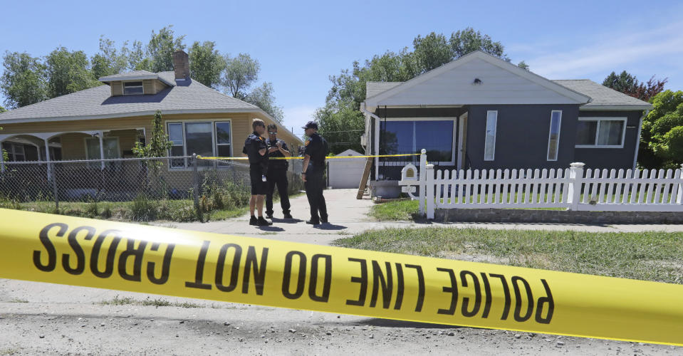 Police officers stand in front of the home, right, of Ayoola A. Ajayi Friday in Salt Lake City. Authorities are filing murder and kidnapping charges in the death of Mackenzie Lueck. A builder claims Ajayi wanted him to build a soundproof wine cellar in his basement with hooks and a thumb print scanner.