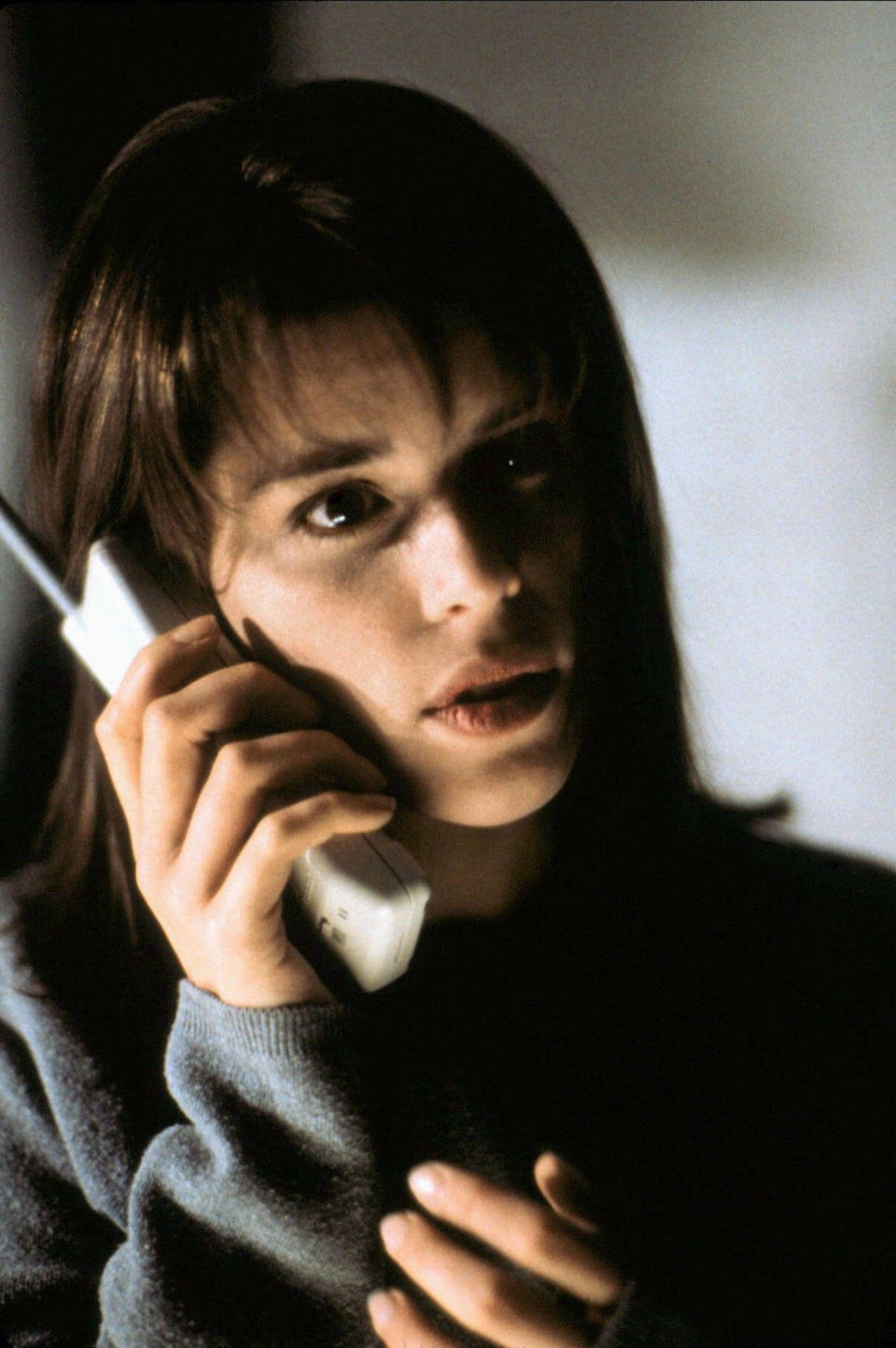 Neve Campbell holds a white phone. (Cinematic / Alamy Stock Photo)