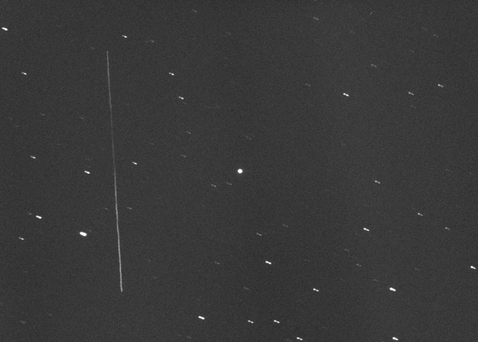 The huge asteroid 3122 Florence appears as a bright dot (center) in this photo taken with a large amateur telescope on Aug. 28, 2017, by Gianluca Masi of the Virtual Telescope Project. At the time, Florence was about 5 million miles (8 million kilometers) from Earth. The long vertical streak at left is the geostationary satellite AMC-14. <cite>Gianluca Masi/Virtual Telescope Project</cite>