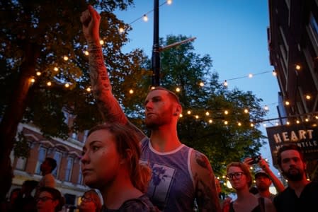 Mourners attend a vigil at the scene after a mass shooting in Dayton