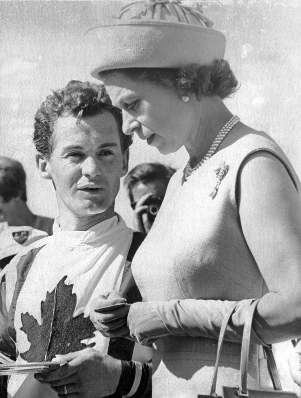 Queen Elizabeth II speaks with jockey Ron Turcotte after presenting Turcotte with the silver plate after riding Fanfreluche to victory in the Manitoba Derby at Assiniboia Downs in Winnipeg, Manitoba, July 15, 1970. “My dad and mother were both very impressed,” Turcotte said.(Canadian Press via AP)