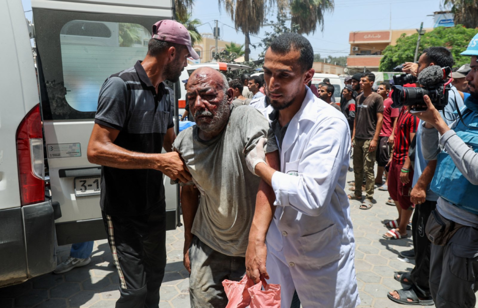  Palestinian man is assisted in the aftermath of an Israeli strike, amid the Israel-Hamas conflict, at Al-Aqsa Martyrs Hospital in Deir Al-Balah