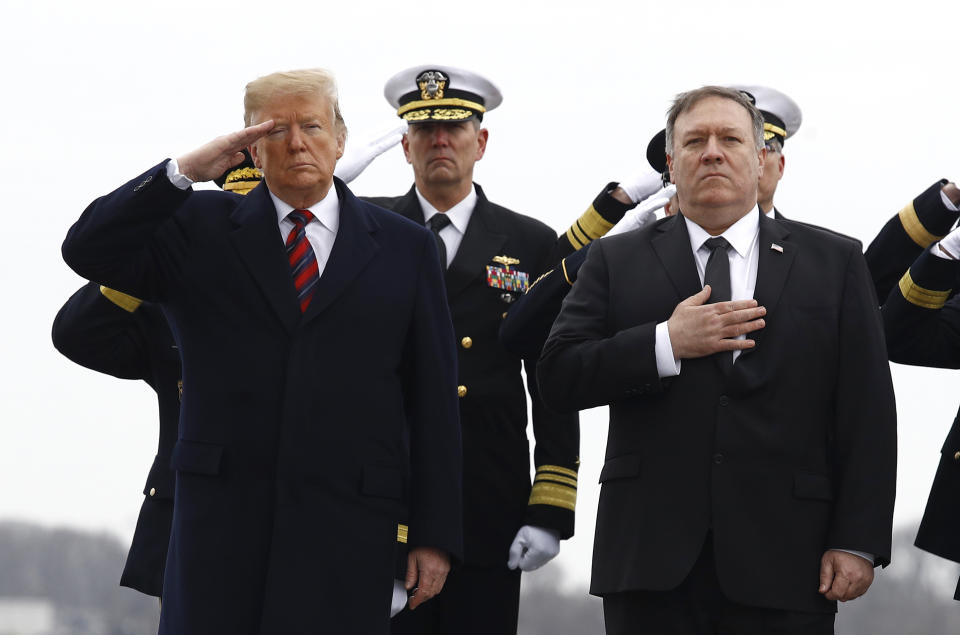 President Donald Trump, left, and Secretary of State Mike Pompeo stand at attention as they await a U.S. Navy carry team moving a transfer case containing the remains of Scott A. Wirtz, Saturday, Jan. 19, 2019, at Dover Air Force Base, Del. According to the Department of Defense, Wirtz, a civilian and former Navy SEAL from St. Louis, Mo., was killed Jan. 16, 2019, in a suicide bomb attack in Manbij, Syria. (AP Photo/Patrick Semansky)