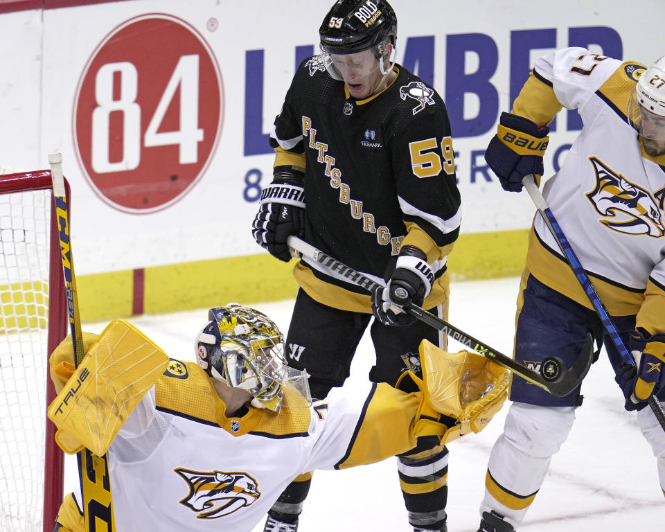 Pittsburgh Penguins' Jake Guentzel (59) can't get a shot off next to Nashville Predators goaltender Juuse Saro, left, with Ryan McDonagh (27) defending during the third period of an NHL hockey game in Pittsburgh, Thursday, March 30, 2023. (AP Photo/Gene J. Puskar)