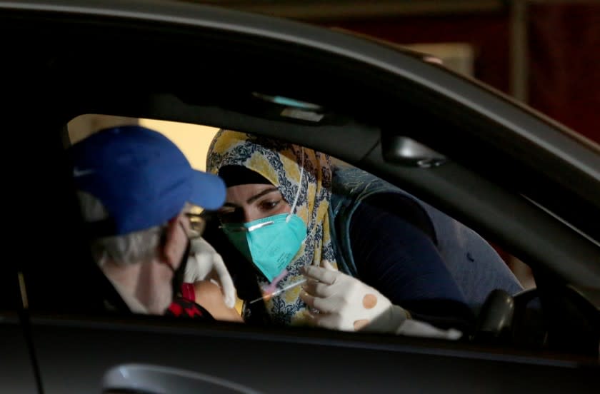 LONG BEACH, CA. - JAN. 21, 2021. Dr. Sarah Mohtadi administers coronavirus vaccine at a drive-in vaccination site at the Long Beach Convention Center on Thursday, Jan. 21, 2021. (Luis Sinco/Los Angeles Times)