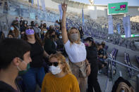 Audience members wear protective face masks during a performance of Israeli musician Ivri Lider at a soccer stadium in Tel Aviv, Friday, March. 5, 2021. All guests were required to show "green passport" proof of receiving a COVID-19 vaccination or full recovery from the virus. (AP Photo/Oded Balilty)