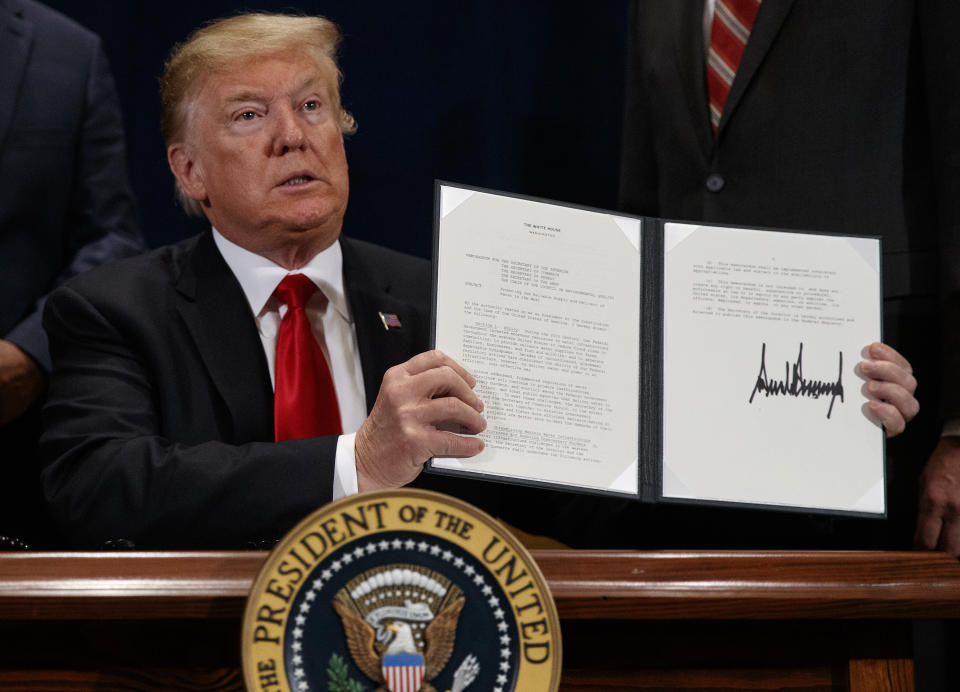 President Donald Trump holds up a "Presidential Memorandum Promoting the Reliable Supply and Delivery of Water in the West," after signing it during a ceremony, Friday, Oct. 19, 2018, in Scottsdale, Ariz. (AP Photo/Carolyn Kaster)