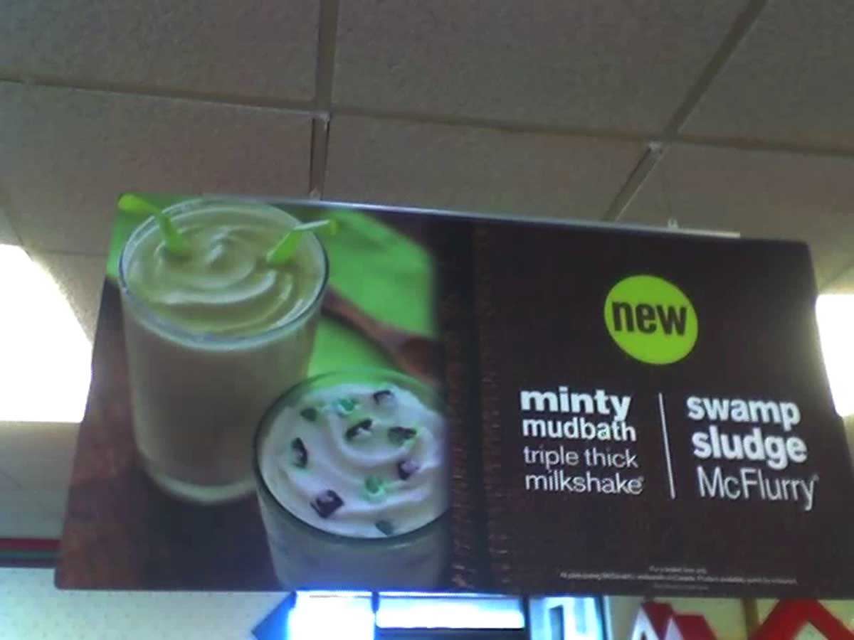 In-store promotional poster for the Minty Mudbath Swamp Sludge McFlurry hanging from the ceiling